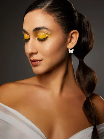 A sunny yellow eyeshadow look with delicate glitter, paired with a bubble ponytail, from our high-floral shoot.