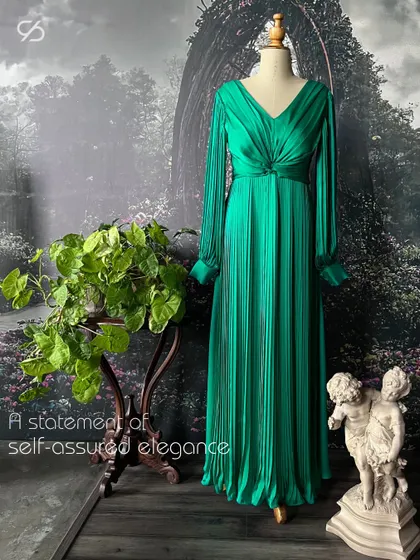 This pleated green gown is a choice that speaks volumes, a canvas for self-expression and confidence. The full sleeves and knotted waist detail create a sophisticated silhouette.