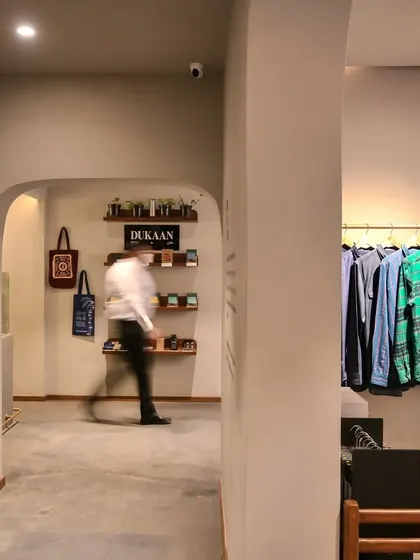 The transition between spaces in the Bombay Shirt Company store is marked by simple, elegant archways, creating a sense of gentle discovery.