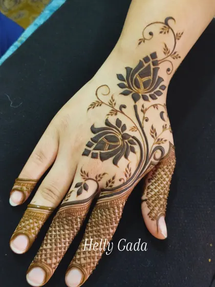 A stunning Arabic-style floral vine that sweeps across the back of the hand. The use of bold, filled-in lotus flowers creates a striking contrast, making this a standout design for any wedding party member.