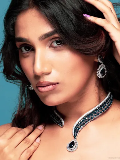 A close-up portrait showcasing the sapphire necklace and matching earrings, perfect for a luxury brand's advertising campaign.