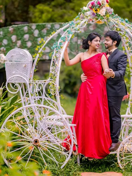 A classic fairy-tale moment with a Cinderella carriage. The couple's pose and the romantic garden setting create a timeless and enchanting pre-wedding photo.