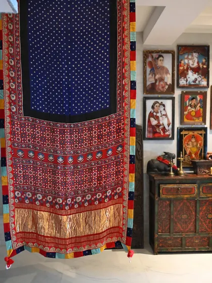 A saree is more than a garment; it is a canvas. Here, a hand-woven silk, dyed with traditional Bandhni and Ajrakh block-printing techniques, hangs as a testament to the artistry involved before it is even draped.