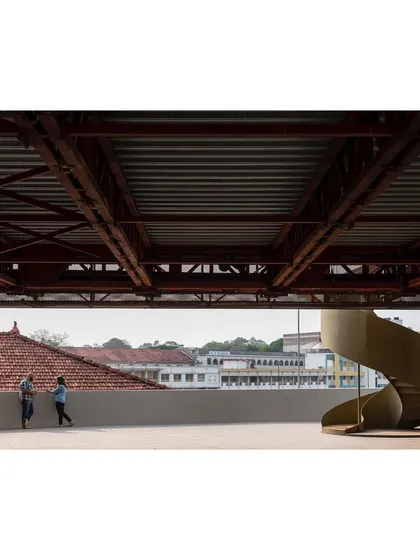 The terrace of the 'Hoverspace' office creates an interstitial event space between the old and new structures. A sculptural spiral staircase connects the levels, offering views across the adjacent sports ground.