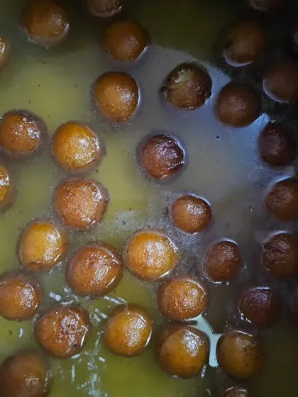 A close-up of our delicious gulab jamuns soaking in sweet syrup, a perfect end to a festive meal.