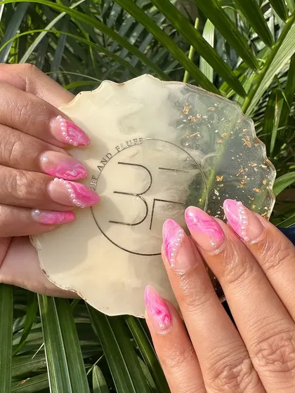 Elevate your style with pink marble nails adorned with delicate pearls. This is a perfect example of an elegant and unique design.
