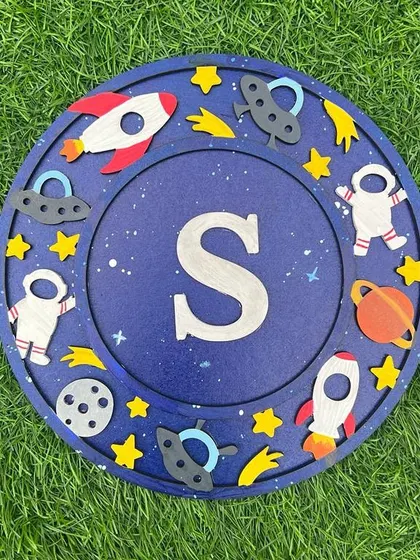 A space-themed monogram perfect for a future explorer! This "S" is surrounded by rockets, planets, and astronauts, making it a stellar piece of personalized art.