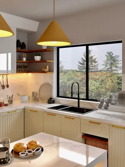 A kitchen design that perfectly frames a window view, featuring cream-colored cabinets, a marble countertop, and warm yellow pendant lights.