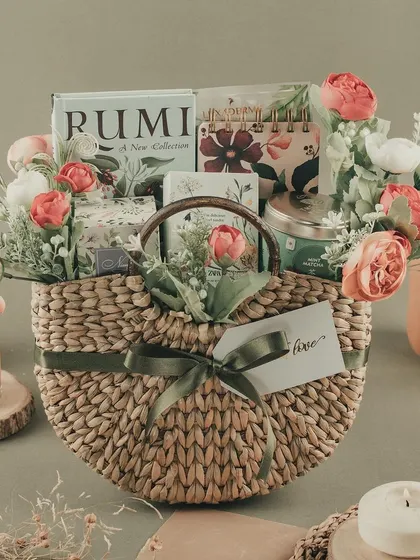 A serene and beautiful gift basket with a floral and botanical theme, featuring a book by Rumi and other calming goodies.
