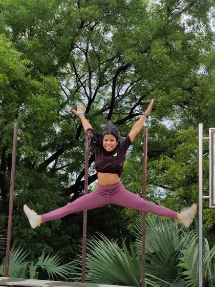 A star jump in the park. Plyometric exercises like this are a fun way to build explosive power and cardiovascular endurance.