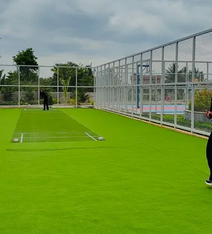 The dedicated cricket practice net at Serene Exotica offers a professional setup for enthusiasts, seamlessly integrated within the larger recreational zone.