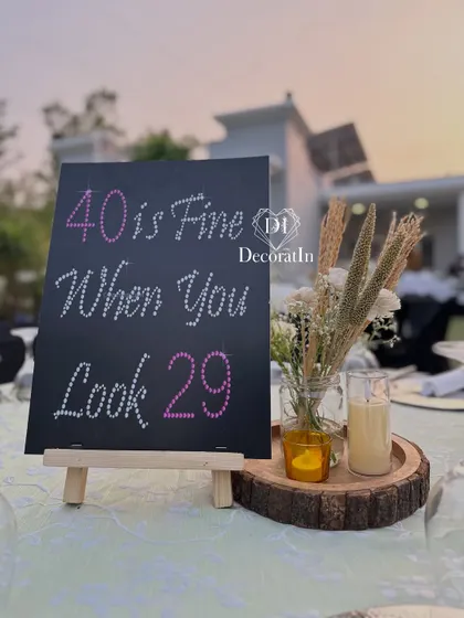 We love adding a touch of humor with our custom signs. This cheeky, rhinestone-studded sign for a 40th birthday reads, "40 is Fine When You Look 29," adding a playful element to the table decor.