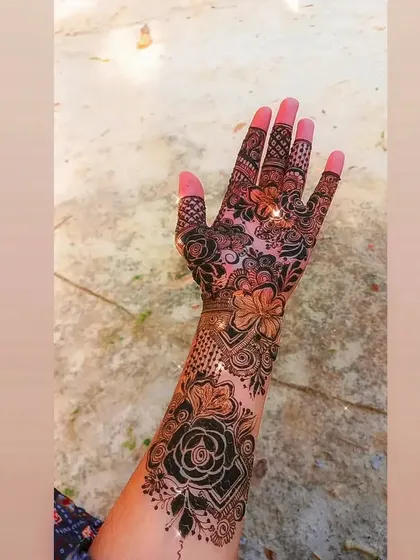 A beautiful 'sider' design with bold roses and delicate leaves, extending from the wrist to the fingers.