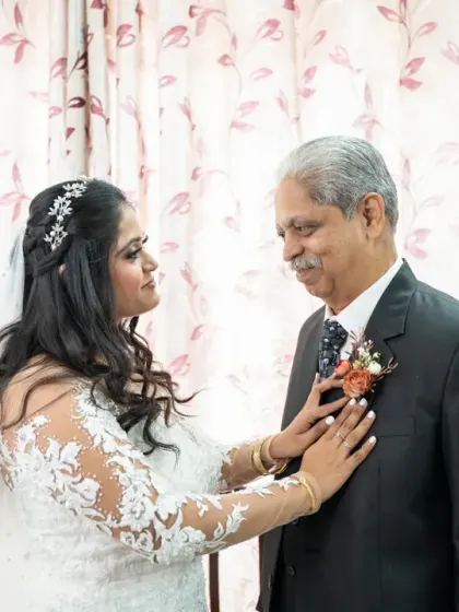 A touching moment between the bride and her father as she adjusts his boutonnière. These family interactions are a core part of the wedding story.