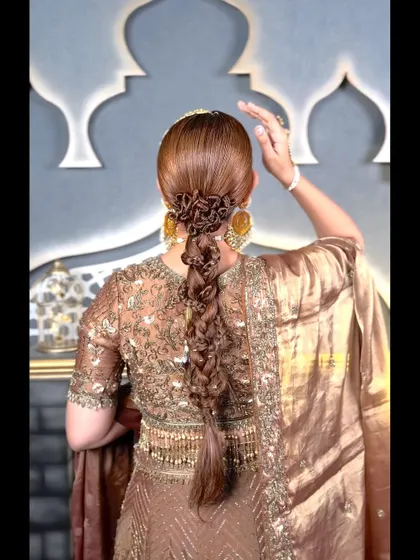 A side view of the intricate bridal braid, showing the beautiful texture and the floral bun at the crown.