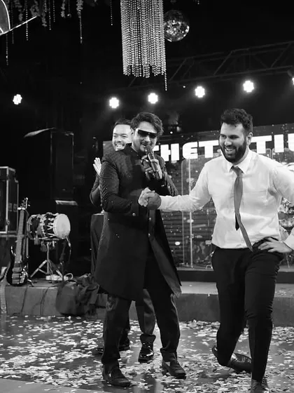 Shaking hands with a guest on stage during a destination wedding Sangeet in Goa. It's all about making connections and ensuring everyone feels like part of the show.