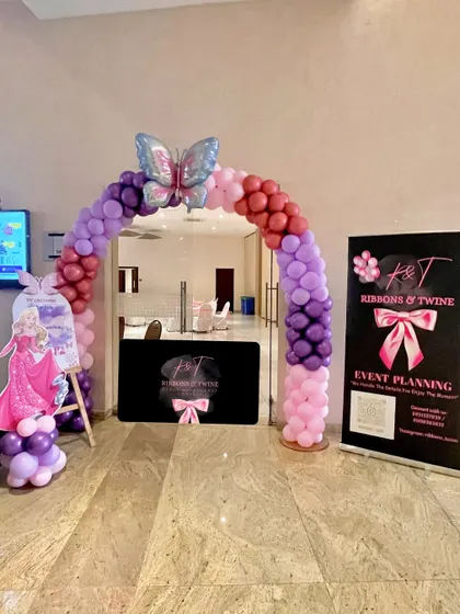 A duplicate image of the butterfly party entrance, showing the welcome arch and standee.