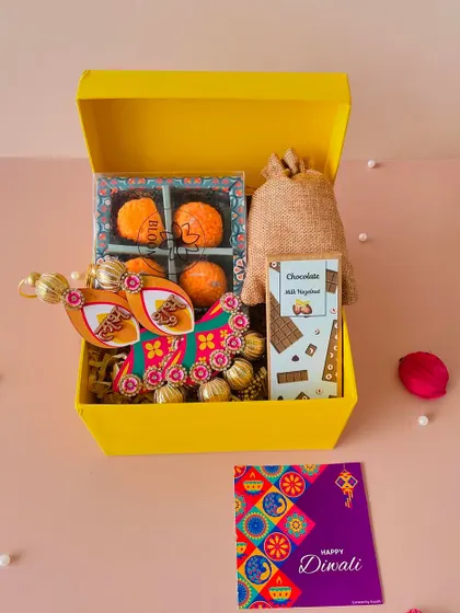This cheerful yellow box contains a complete set of festive goodies, including laddoo candles and a door hanging, offering great value.