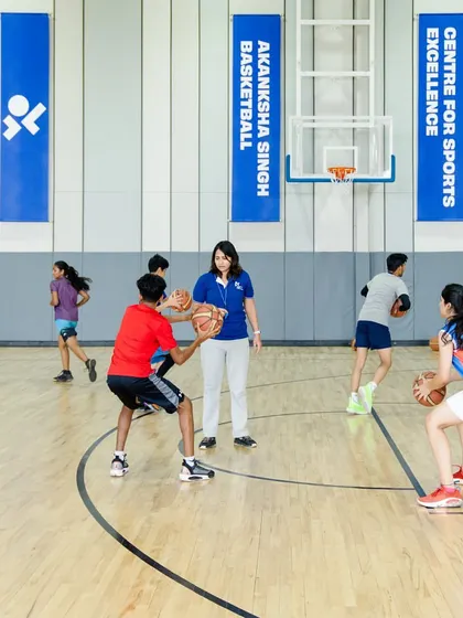 A coach guiding players through a drill during our 2023 summer camp.