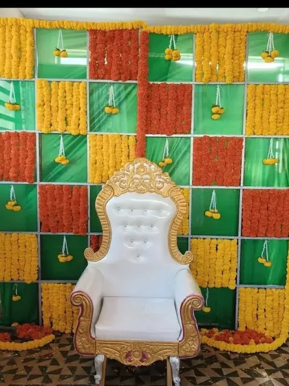 A vibrant backdrop for a Haldi or Mehendi ceremony, featuring a chequered pattern of orange and yellow marigolds. We've added a traditional white throne to complete the seating arrangement for the main ceremony.