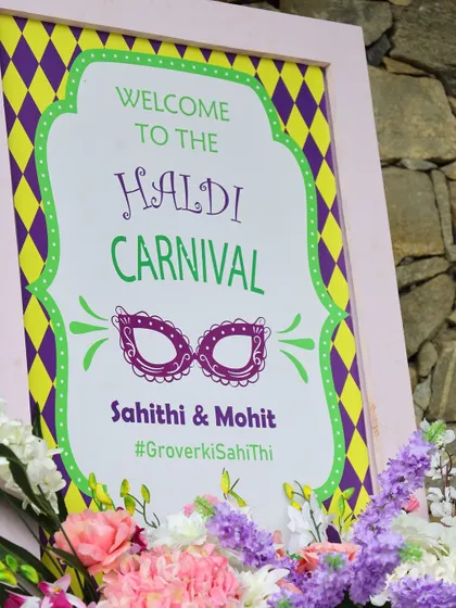 A closer look at the Haldi Carnival welcome sign, framed with beautiful pastel flowers.
