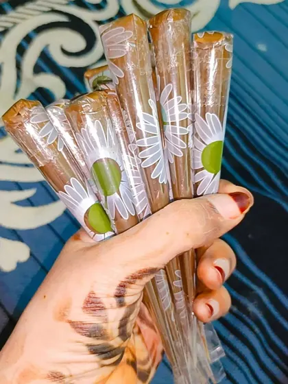 Holding a fresh bundle of organic henna cones. The design on my hand was made with the very same paste.