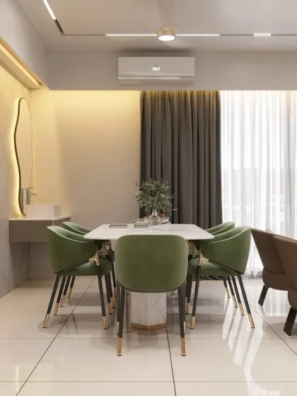 Part of a larger open-plan space, this dining area is defined by its bold green velvet chairs. A sleek, wall-mounted washbasin and an organically shaped mirror add a unique, functional touch to the area.