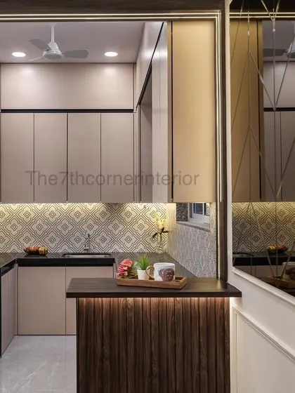 An open kitchen design that enhances visibility and extends the dining area. The beige color palette makes the space appear brighter and airier, and the small breakfast counter is perfect for quick meals.