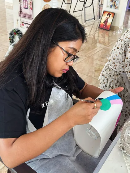 Another artist at work on her personalized lampshade, creating a colorful abstract pattern.