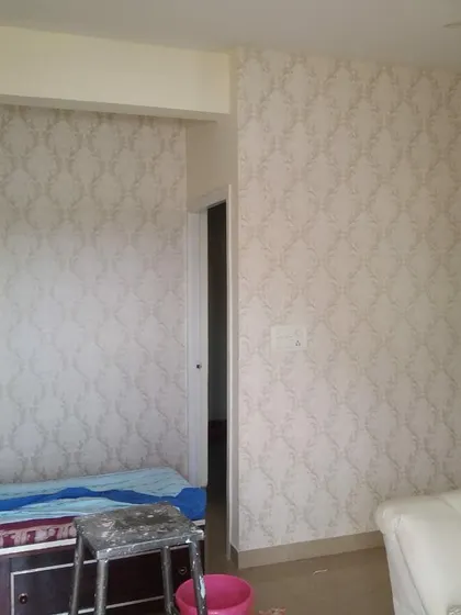 A full room installation of a light, neutral damask wallpaper, making the space feel bright and cohesive.