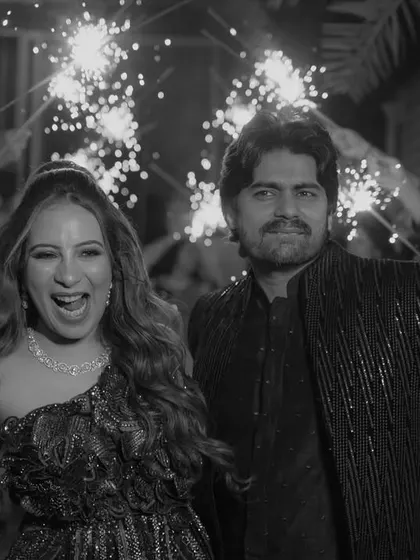 A celebratory entrance at a cocktail party, with the couple walking through a tunnel of guests holding sparklers.