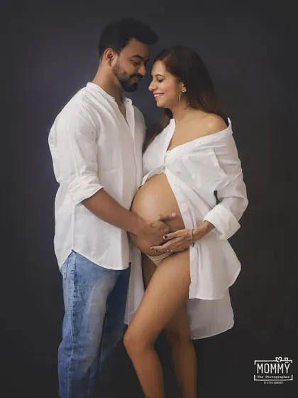 A beautiful and intimate couple's maternity portrait. The focus is on their connection and the beautiful baby bump, creating a timeless and loving memory.