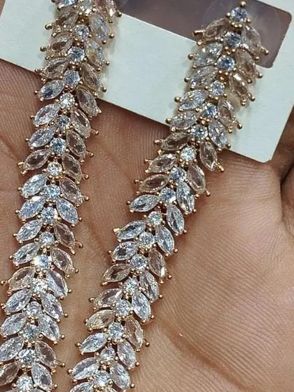 These elegant, leaf-patterned dangler earrings are made with marquise-cut American diamonds. The design is simple yet very sparkly, making them a great choice for both Indian and Western outfits.
