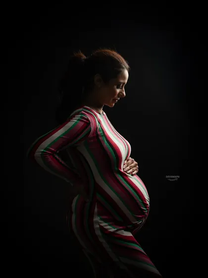 This color version of a low-key portrait shows how the striped dress adds another layer of visual interest. The dramatic lighting still creates that intimate, artistic feel.