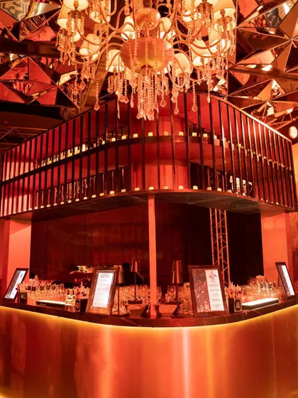 The bar at the U+S Sangeet, glowing under a futuristic mirrored ceiling. The design was inspired by Singapore's vibrant nightlife, blending modern materials with glamorous lighting.