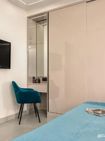 This bedroom design includes a hidden dressing table within the sliding wardrobe unit. It’s a perfect space-saving solution that keeps the room looking tidy and uncluttered.