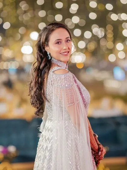 A beautiful reception look with a stunning bokeh background. The makeup is soft and romantic, with a focus on glowing skin and gentle pink tones on the eyes.