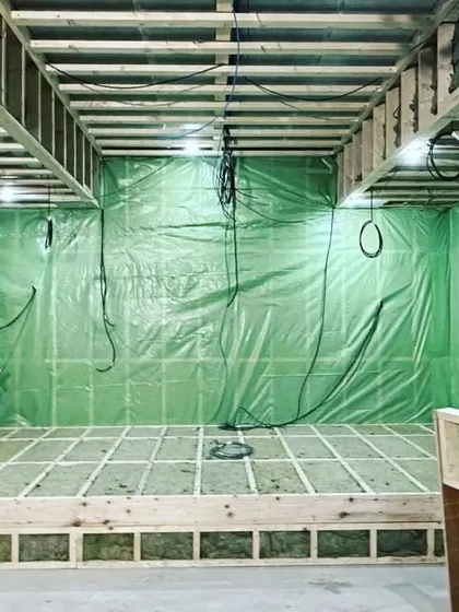 A look at the "room within a room" construction method. The green layer is a vapor barrier, and the cavities are filled with insulation to completely isolate the theater from outside noise and vibrations.