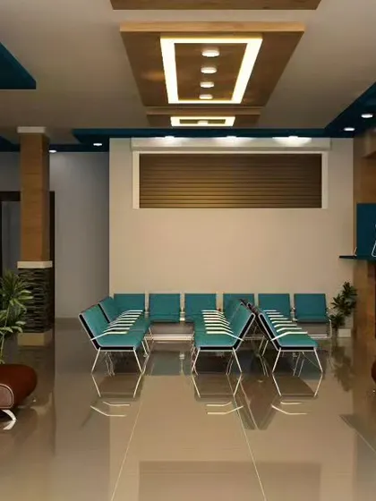 A practical and modern waiting room design featuring a multi-level false ceiling with recessed lighting. The layout provides ample seating, and the inclusion of potted plants adds a touch of nature to the commercial space.