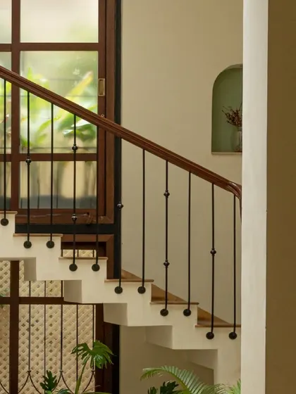 The simple, elegant lines of the staircase railing contrast with the intricate patterns of the screens and tiles, creating a balanced and visually interesting composition.