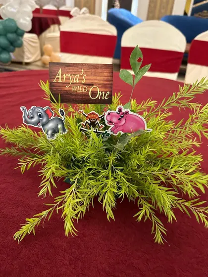 Even the table centerpieces matched the theme! We created these small arrangements with faux greenery and cute animal cutouts for the "Wild One" birthday party.