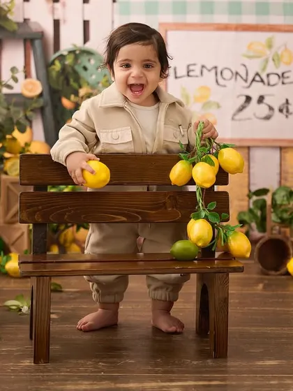 Full of excitement at the lemonade stand. We capture the energy and personality of your baby as they interact with our creative sets.
