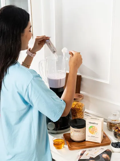 A model adding a supplement to a smoothie, showcasing another versatile way to use the product.