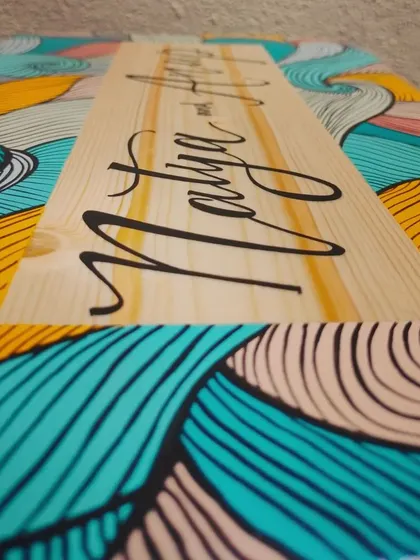 A detailed angle of our boho-style name plaque. The intricate line work is done entirely with a fine paintbrush, showing the care and precision that goes into each piece.
