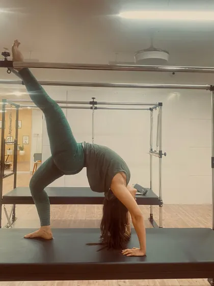 This one-legged bridge on the Cadillac is a powerful expression of strength and flexibility. It requires open hips, a strong back, and stable shoulders to hold the position with grace.