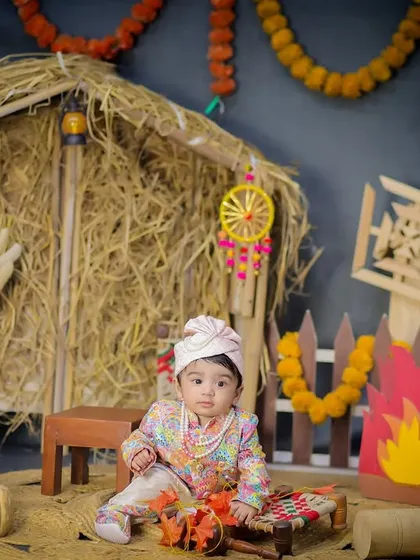 A classic portrait from the Lohri theme, with the baby looking sweetly at the camera in a festive and warm setting.
