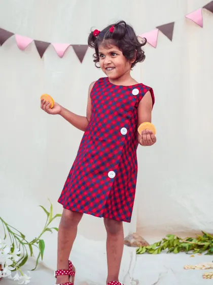 A playful moment in the red and navy check dress. Made from soft, breathable fabric, it's designed to keep her comfortable during all her adventures.