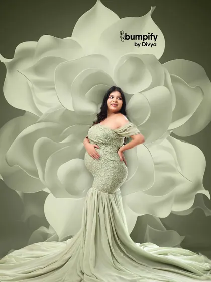 A powerful and artistic pose with the mom-to-be in a form-fitting green lace gown against a giant white flower backdrop. This shot beautifully highlights the curves of pregnancy.