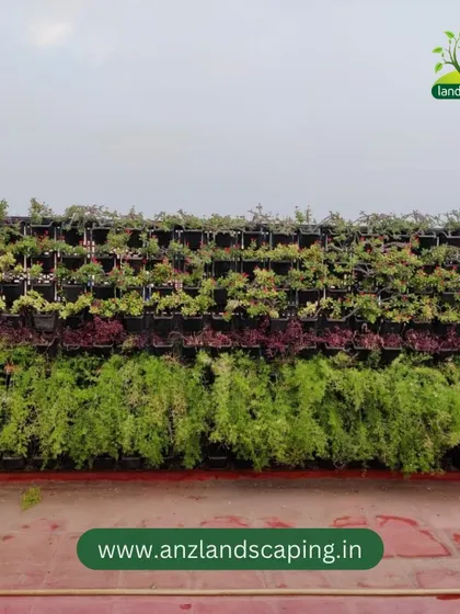 This large-scale vertical garden was installed on a rooftop, creating a massive green facade. The design uses bands of different plant types, including flowing asparagus ferns and colorful foliage, to create a striped, textured pattern.