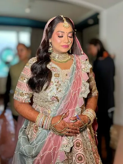 The bride with her eyes closed, showing the delicate pink eyeshadow and flawless base.